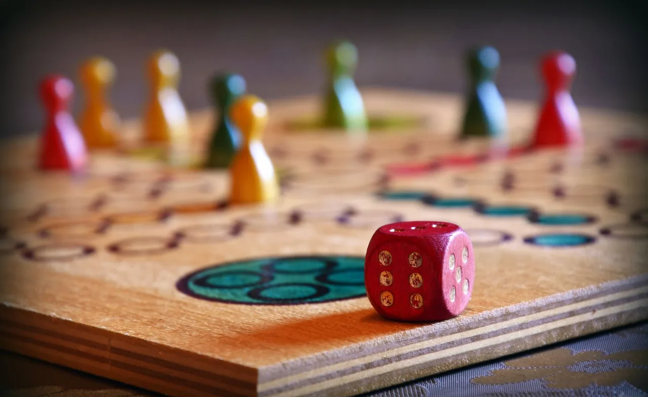 Pawns and a die on a wooden board