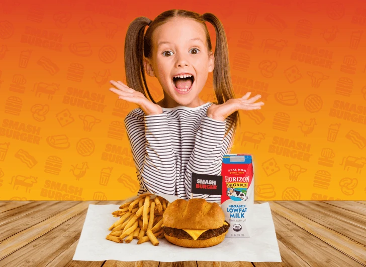 Smashburger 官方儿童餐宣传图，儿童面前摆着汉堡、薯条与牛奶