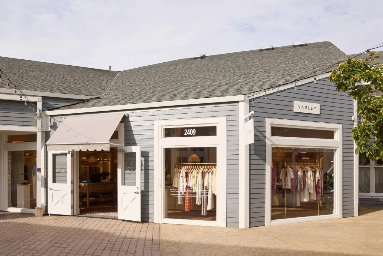 Varley 门店外观：灰色木墙、白色窗框和门牌 2409，橱窗里挂着衣服